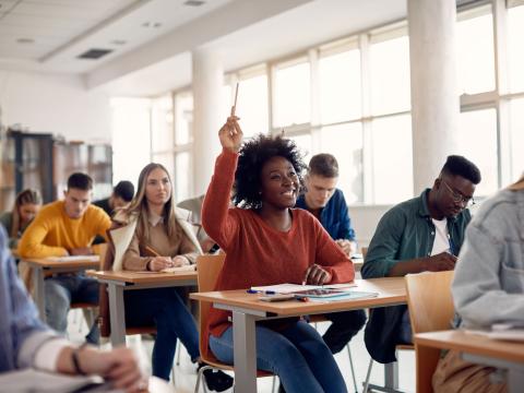 College student in class, raising their hand.