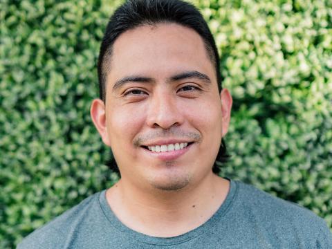 Student headshot in front of a leaf wall.