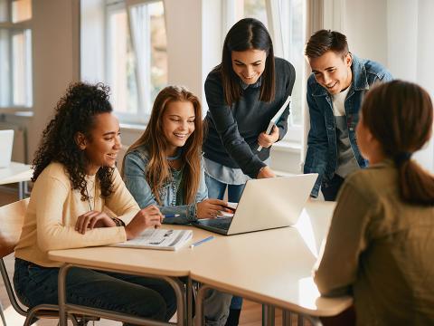 Five high school students sitting around a table.