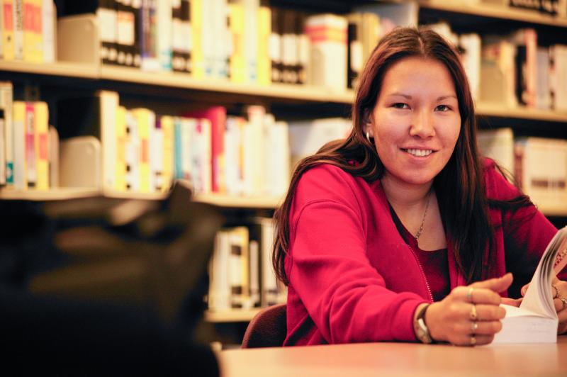 Student in a library setting, sitting at a table.