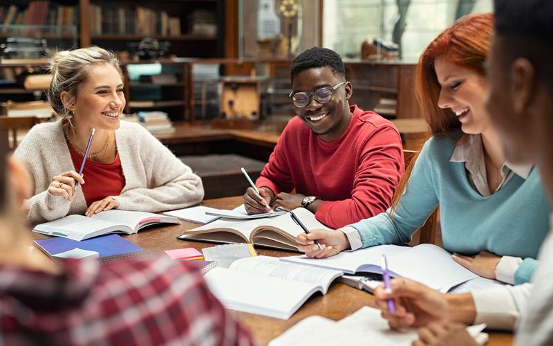 Four college aged students sitting around a table.